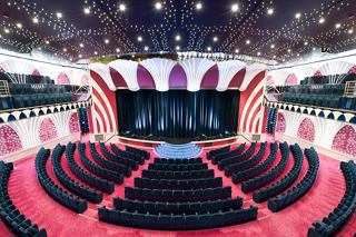Una amplia área de asientos en el teatro con un escenario listo para una actuación en el MSC Orchestra | MSC Cruceros