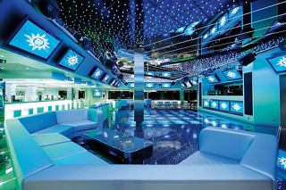 Une piste de danse vibrante avec un bar et des sièges confortables, invitant les invités à profiter des divertissements à bord | MSC Croisières
