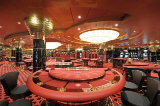 A vibrant casino with red decor and gaming tables inviting guests to enjoy thrilling entertainment experiences | MSC Cruises