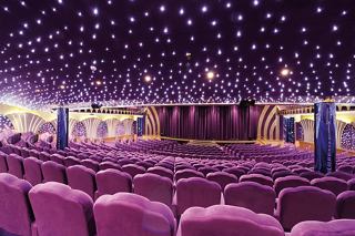 A spacious theatre with plush seating, a vibrant stage, and a starry ceiling, perfect for unforgettable performances | MSC Cruises