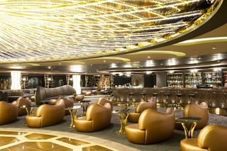 A stylish lounge area featuring comfortable seating and a vibrant bar counter, perfect for relaxation and socialising | MSC Cruises