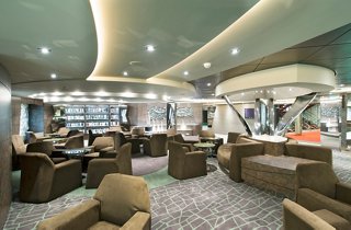 A welcoming lounge area with comfortable seating and a library, perfect for relaxation and leisure | MSC Cruises