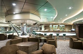 An inviting lounge area with comfortable seating and a stylish bar, perfect for relaxation on board | MSC Cruises