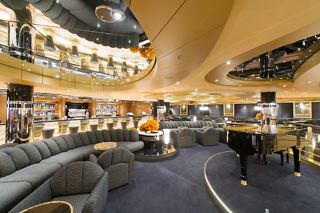 Ein stilvoller Barbereich mit Klavier, bequemen Sitzgelegenheiten und einer einladenden Atmosphäre zum Entspannen und Genießen | MSC Cruises