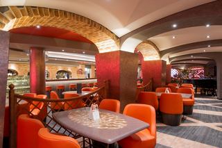 A welcoming bar area with vibrant orange armchairs and a warm atmosphere for relaxation and socialising | MSC Cruises
