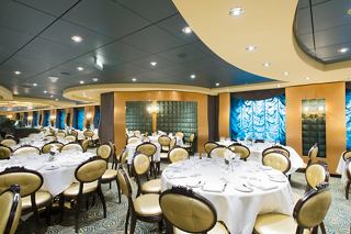 Elegant dining setup in The Golden Lobster restaurant aboard MSC Preziosa, featuring tables and chairs with a scenic view | MSC Cruises