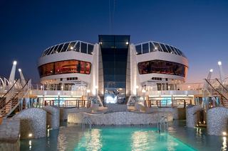 The MSC Splendida features a stunning pool area illuminated at night, showcasing its elegant design and vibrant atmosphere | MSC Cruises