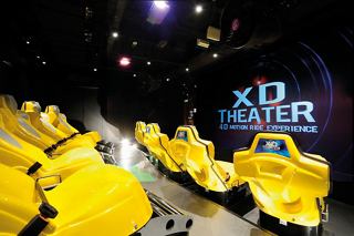 Des sièges de cinéma jaune vif disposés dans un lieu de divertissement moderne avec un grand écran affichant le logo MSC | MSC Cruises