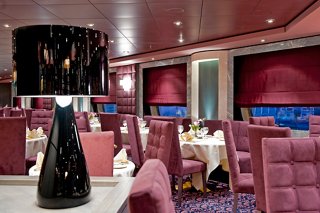 Un restaurant accueillant avec des tables élégantes et des lampes, prêt à recevoir les invités | MSC Croisières