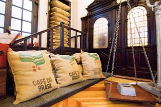 A warm interior featuring a wooden scale and coffee sacks, inviting exploration of Santos' rich heritage | MSC Cruises