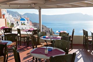 A serene dining area overlooking the sparkling sea in Santorini, inviting guests to enjoy Mediterranean cuisine | MSC Cruises