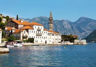 A charming coastal view of Perast, Montenegro, with picturesque houses and a church by Kotor Bay | MSC Cruises