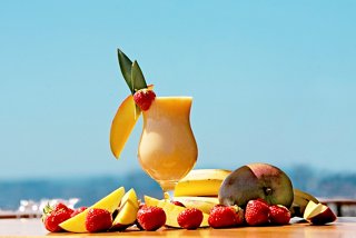 A refreshing smoothie made with banana, mango, and strawberry sits on a bar counter by the sea | MSC Cruises