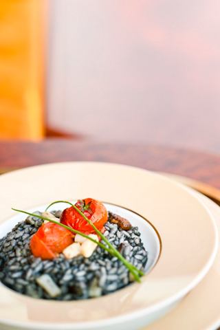 A beautifully presented plate of black rice garnished with fresh tomatoes, perfect for a memorable dining experience | MSC Cruises