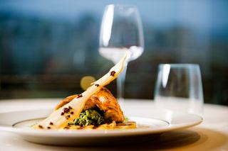 A beautifully plated chicken dish garnished with pineapple, alongside elegant glassware, awaits at MSC Yacht Club | MSC Cruises