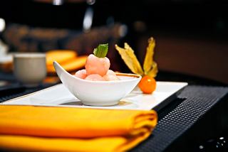 Un plat joliment présenté avec des fruits frais et des garnitures sur une table avec des serviettes jaunes vives | MSC Croisières