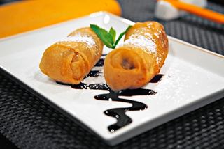 Disfruta de un postre bellamente presentado que incluye dos rollos crujientes decorados con menta fresca | MSC Cruceros