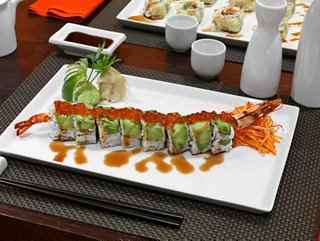 Un roll de sushi bellamente presentado con wasabi y jengibre en una mesa de comedor en Kaito Sushi Bar | MSC Cruceros