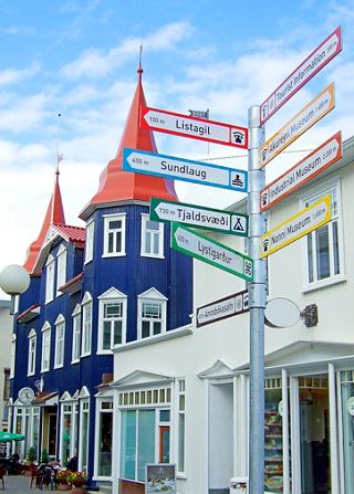 Charming buildings with colourful roofs and directional signs in Akureyri, Iceland under a clear blue sky | MSC Cruises