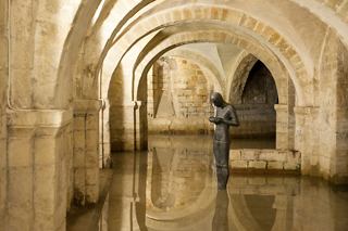 A serene interior view featuring a statue surrounded by arches and calm water, inviting exploration and reflection | MSC Cruises