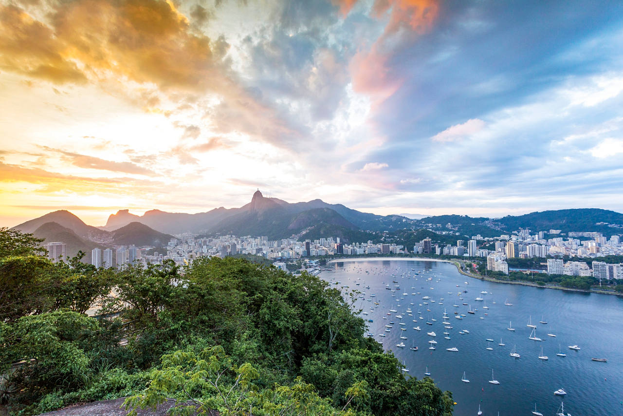 Une vue panoramique de Rio de Janeiro au coucher du soleil, montrant des montagnes, la mer et la ville vibrante | MSC Cruises