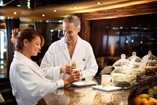 Una pareja disfruta de una bebida refrescante juntos en el bar, rodeados de un ambiente cálido y acogedor | MSC Cruceros