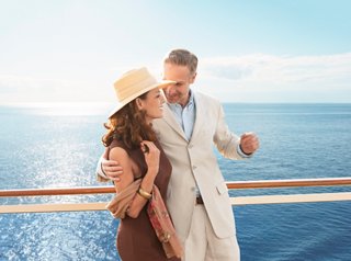 Una pareja de ancianos disfruta de la compañía del otro en la cubierta del MSC Splendida con el mar de fondo | MSC Cruceros