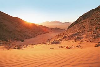 Una vista impresionante del desierto de Namib al atardecer, con tonos cálidos y paisajes cautivadores | MSC Cruceros