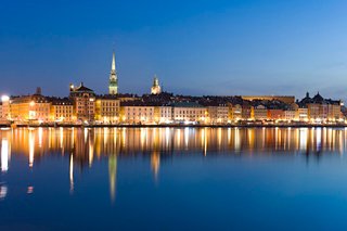 Vue nocturne de Stockholm avec un front de mer illuminé se reflétant dans l'eau | MSC Cruises