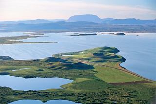 A panoramic view of a serene lake surrounded by lush vegetation and mountains in Akureyri, Iceland | MSC Cruises