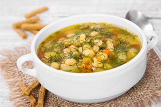 A warm bowl of hearty vegetable soup with beans and potatoes, accompanied by a spoon, ready to enjoy | MSC Cruises