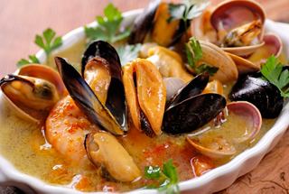 A delicious seafood dish featuring mussels and shrimp, garnished with fresh herbs | MSC Cruises