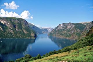 Eine atemberaubende Fjordlandschaft in Norwegen spiegelt den blauen Himmel und die Berge wider und lädt zur Erkundung und Abenteuer ein | MSC Cruises