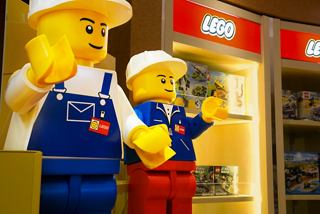 Zwei fröhliche Lego-Figuren in einem Geschäft, laden Gäste ein, das lustige Einkaufserlebnis zu erkunden | MSC Cruises