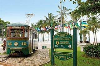 Eine charmante Straßenbahn an einem lebhaften Zielzeichen in Santos, umgeben von üppigem Grün und einladenden Fahnen | MSC Cruises