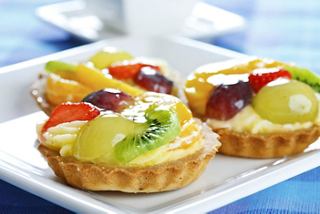 Delightful fruit tarts topped with vibrant fruits on a white plate | MSC Cruises