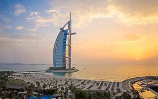 The iconic Burj Al Arab stands majestically against a vibrant sunset sky in Dubai | MSC Cruises