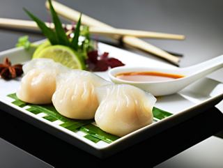A beautifully arranged plate of Har Kau dumplings served with fresh garnishes and dipping sauce | MSC Cruises