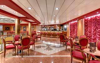 Bar confortable avec des meubles rouges et des tables pour se détendre à bord de MSC Sinfonia | MSC Croisières