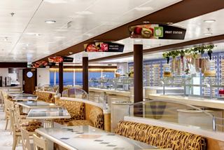 Un restaurant confortable avec des tables et des chaises, offrant un buffet et des fenêtres donnant sur la mer | MSC Croisières