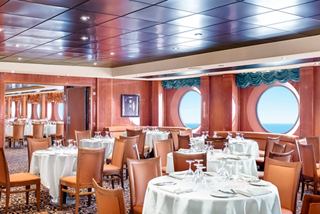 Eleganter Speisesaal mit gedeckten Tischen und Stühlen, beleuchtet von natürlichem Licht | MSC Cruises
