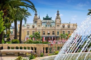 The iconic Casino de Monte-Carlo surrounded by lush greenery and a beautiful fountain | MSC Cruises