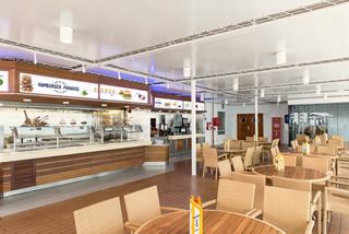 Un espace de restauration accueillant au La Terrazza Buffet sur le MSC Sinfonia, avec des tables en bois et une atmosphère lumineuse | MSC Croisières