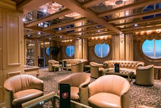 Un salon chaleureux avec des canapés et des tables élégants, offrant de grandes fenêtres pour des vues pittoresques | MSC Croisières