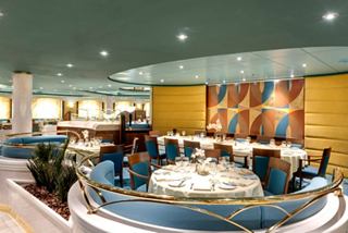 Ein lebhaftes Esszimmer mit eleganten Tischen und Stühlen, das die Gäste einlädt, gemeinsam zu speisen | MSC Cruises