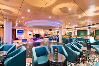 A stylish bar area with comfortable seating and a vibrant stage for live performances | MSC Cruises