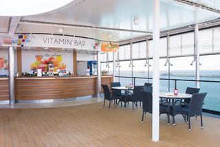 A spacious lounge area featuring a bar counter with seating and large windows for natural light | MSC Cruises