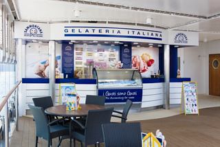 A vibrant Gelateria Italiana bar with seating, offering delightful ice cream on board MSC Opera | MSC Cruises