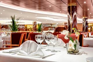 Ambiente elegante en un restaurante con mesas bellamente decoradas y arreglos florales | MSC Cruceros
