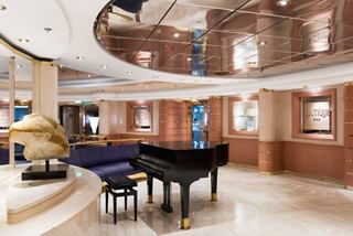 Un elegante salón con un piano y una decoración sofisticada, invita a los huéspedes a relajarse y disfrutar de la música | MSC Cruceros